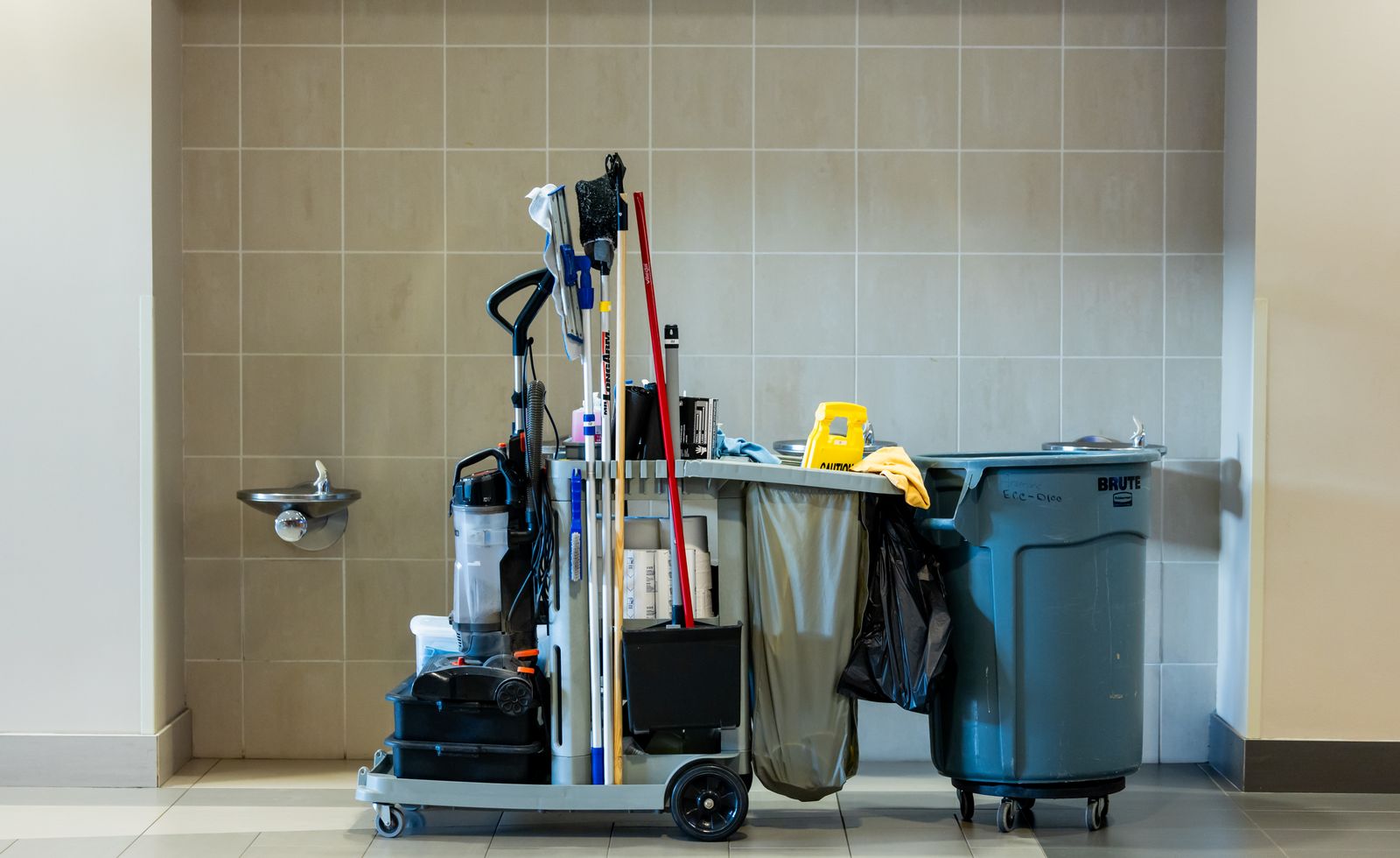 Commercial cleaning supplies and cart staged inside a freshly built-out commercial space