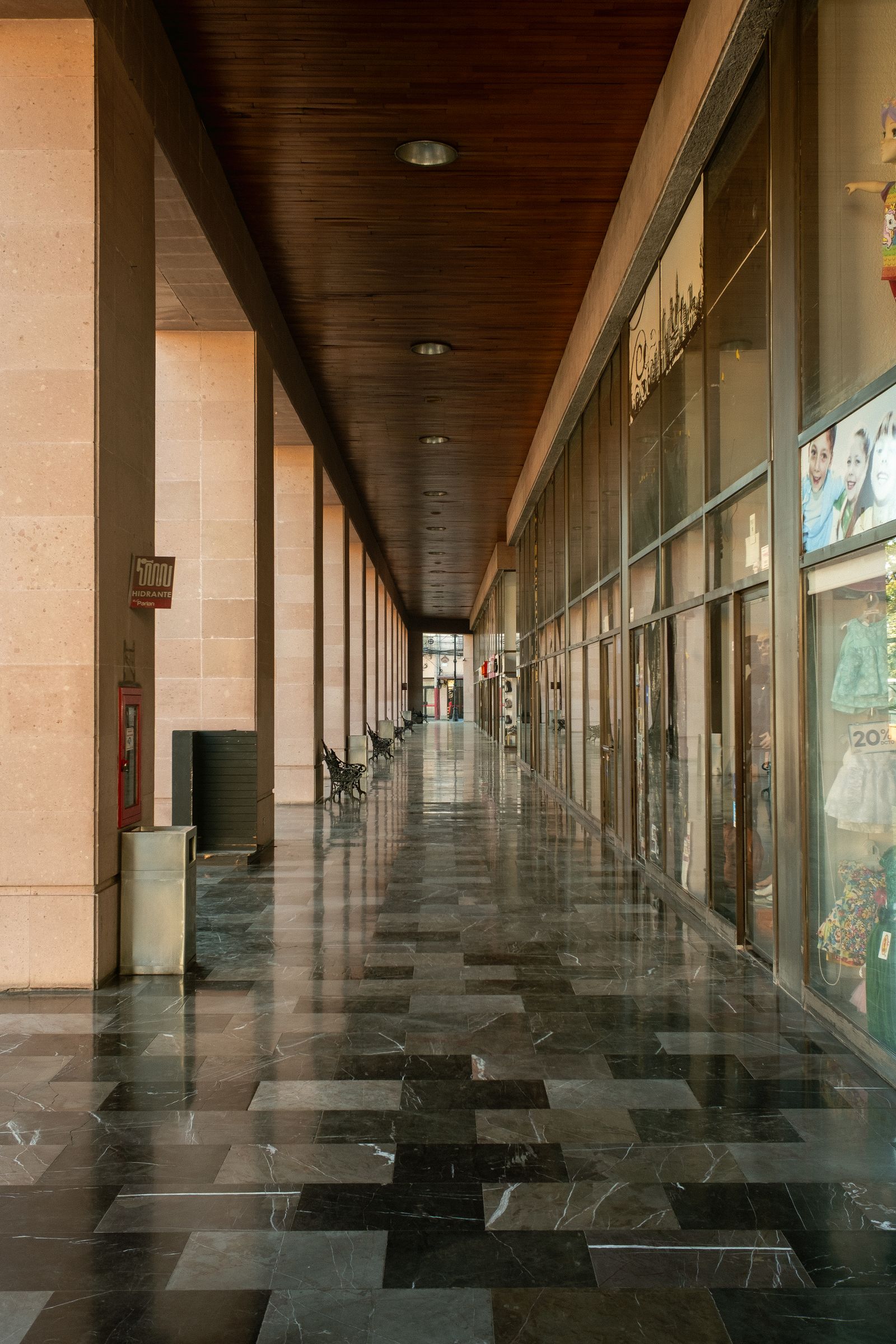 Polished marble floor in a long commercial corridor reflecting overhead lighting